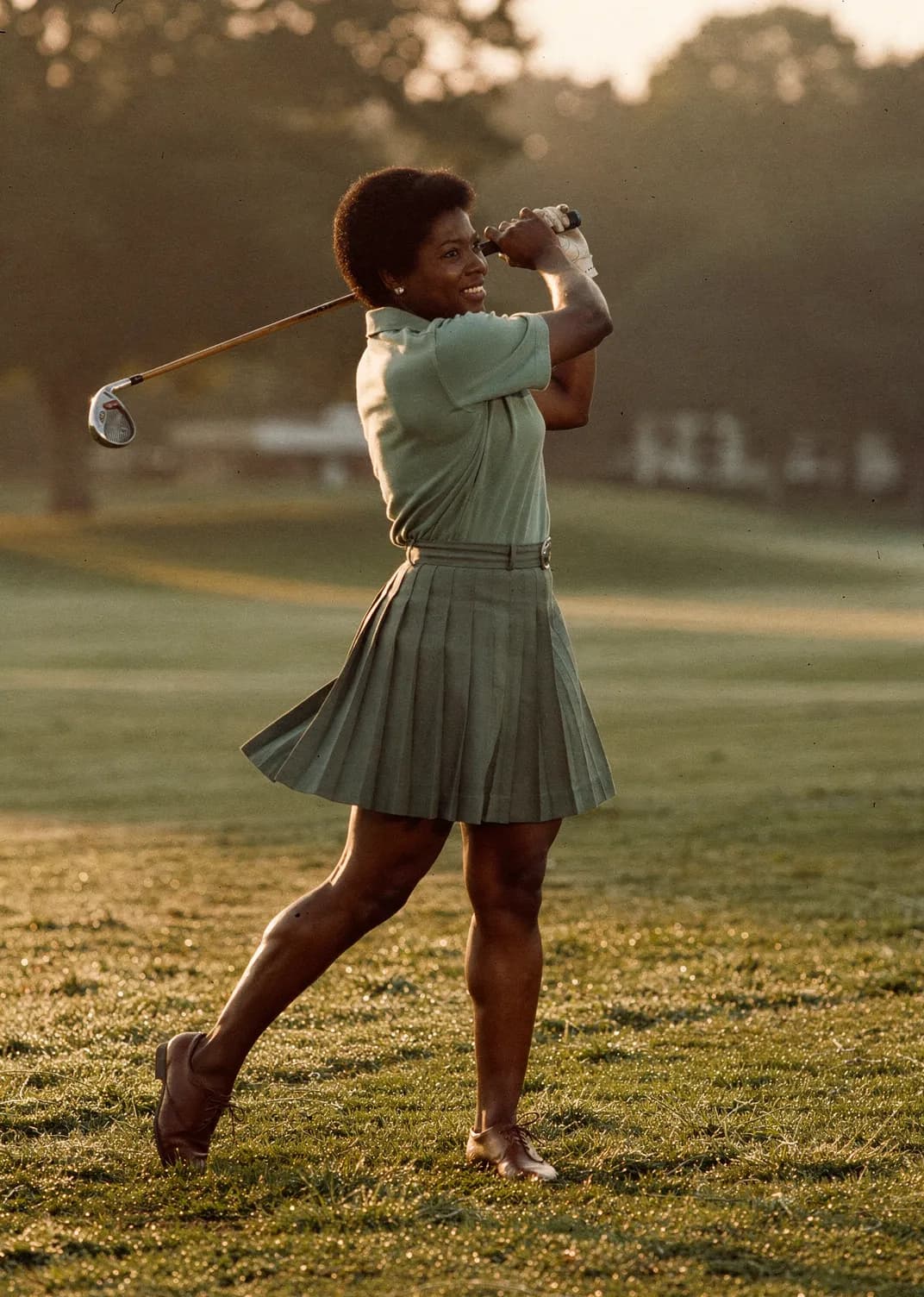 Golfer mid-swing on an early morning fairway
