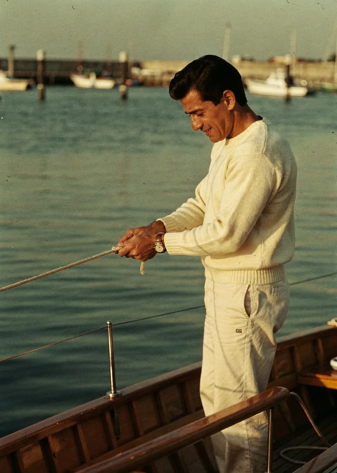 Sailor trimming a line on a small day boat